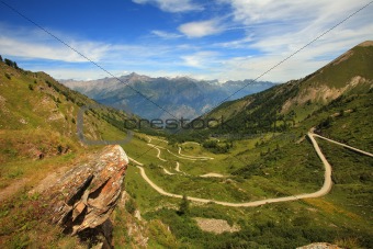 Unpaved road in the valley in Alps, italy.