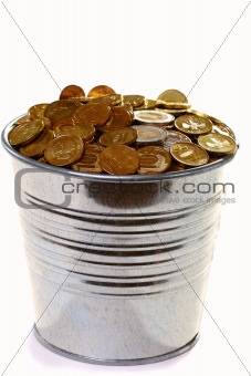 Zinc bucket of gold coins on a white background.