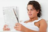 Close up of a young man reading a newspaper