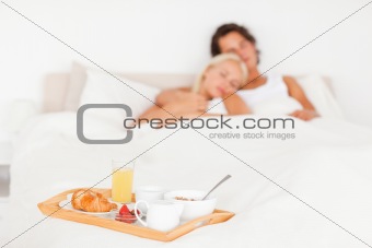 Cute couple with the breakfast put on a tray