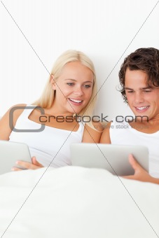 Portrait of a smiling couple using tablet computers