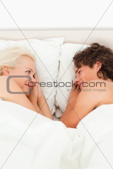 Portrait of a couple lying while looking at each other
