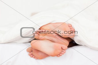 Stack of feet in a bed