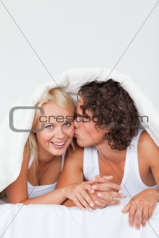 Portrait of a man kissing his girlfriend on the cheek