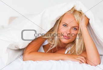 Blonde woman under a duvet
