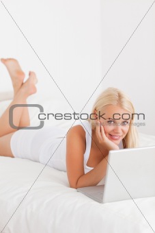 Portrait of a woman using a laptop on her bed