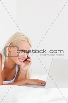 Portrait of a woman on the phone using a notebook