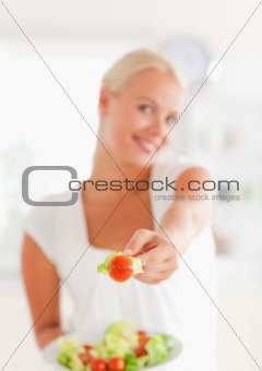 Portrait of a woman giving a tomato