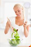 Portrait of a smiling woman mixing a salad