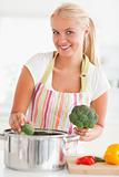 Portrait of a smiling woman putting cabbage on water