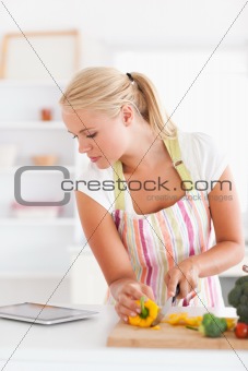 Portrait of a blonde woman using a tablet computer to cook