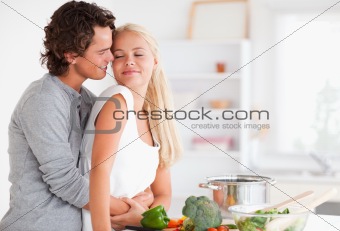 Cute couple hugging while cooking