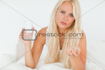 Blonde woman showing a pill