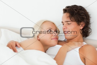 Close up of a couple lying on a bed hugging