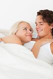 Close up of a couple lying on a bed hugging