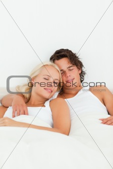 Portrait of a couple sleeping in their bedroom