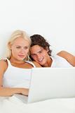 Portrait of a couple watching a movie with a laptop