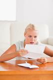 Woman looking at a letter in shock