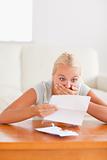 Shocked cute woman reading a letter