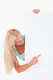 Blond-haired woman pointing at a whiteboard