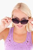 Charming lady peeking over her sunglasses 