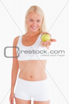 Charming blond woman holding an apple