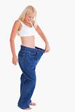 Smiling woman wearing to big jeans