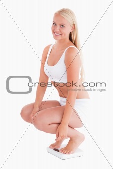 Woman crouching on a scale