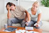 Worried couple calculating expenses