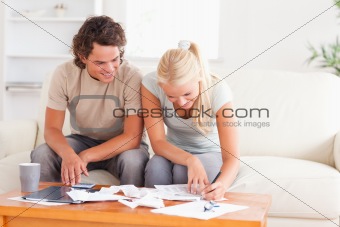 Smiling couple calculating their expenses