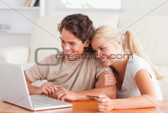 Cute couple with a laptop and a credit card