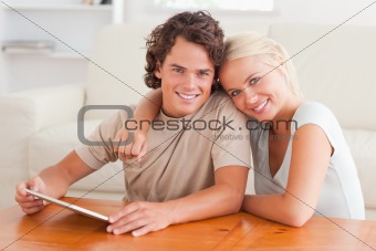 Hugging cute couple with a tablet
