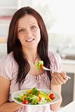Woman with salad looking into camera