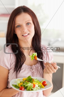 Woman with salad looking into camera