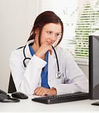 Female doctor looking to pc screen