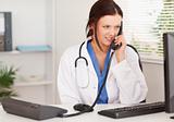 Female doctor telephoning in office