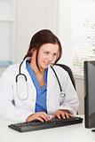 Female doctor typing on keyboard in office