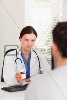 Female doctor giving patient pills