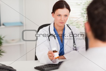 Female doctor giving a patient pills