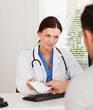 Female doctor presenting prescription to patient