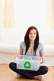 Sitting woman holding recycling bin
