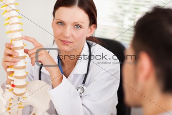 A female doctor showing patient a spine