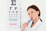 Female optician with eye test in office