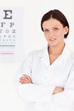 Female optician with crossed arms and eye test