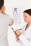 Female optician testing eyes of a man