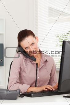 Businesswoman with phone typing 