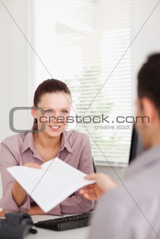 A businesswoman presents a contract to a customer