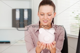 Woman looking at her piggy bank
