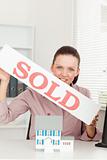 Businesswoman holding sold sign
