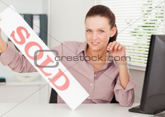 Businesswoman shows sold sign